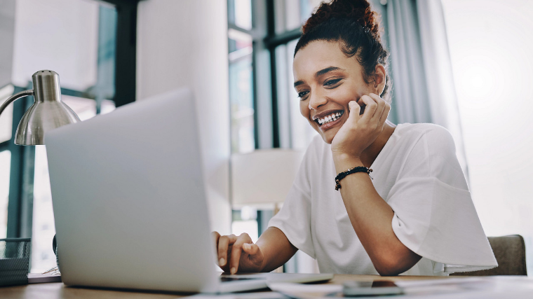 Woman smiling looking at a laptop
