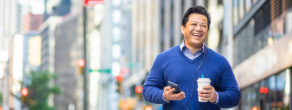 Smiling Asian man holding a coffee